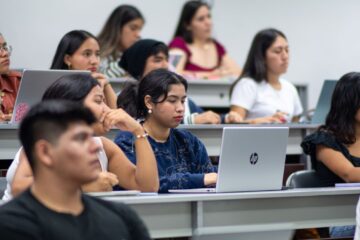 A diverse group of students attentively listens during a university lecture in Piura, Peru.