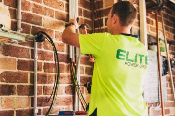 Electrician performing solar battery installation for sustainable energy storage in a home setting.