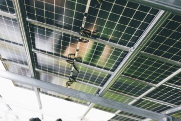 Close-up of solar panels being installed outdoors with technicians visible.